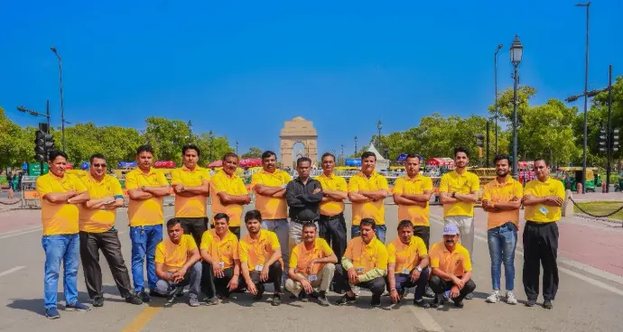 alt="Group photo of 50 professional, uniformed drivers standing confidently with happy smiles"
